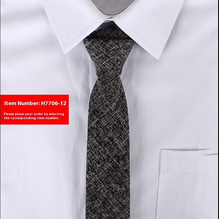 Close-up of a black and white narrow cotton tie on a white dress shirt with pointed collar