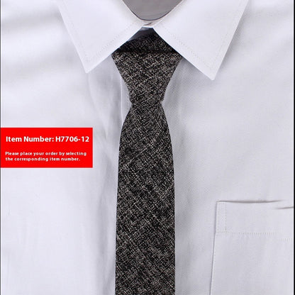 Close-up of a black and white narrow cotton tie on a white dress shirt with pointed collar