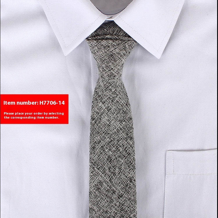 Close-up of a textured gray slim cotton tie worn with a white dress shirt in a business casual style