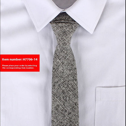 Close-up of a textured gray slim cotton tie worn with a white dress shirt in a business casual style