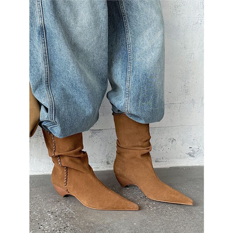 Brown suede pointed toe western boots with slouchy design worn with light blue jeans