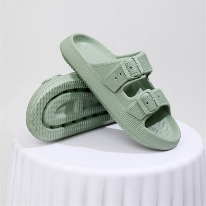 Pair of light green thick-soled EVA sandals with adjustable double buckle straps on white surface