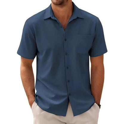 Man wearing short sleeve navy blue casual button-up shirt with chest pocket and beige pants