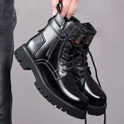 Hand holding black men's leather lace-up boots with thick soles and side zippers against gray background