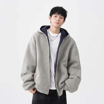 Young man wearing light gray oversized hooded sweater jacket with double zipper and white t-shirt