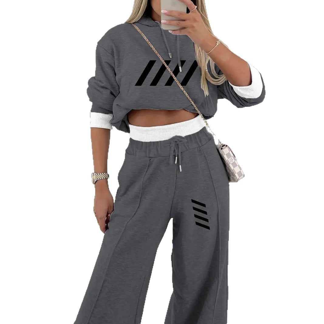 Woman in dark gray cropped hoodie and matching wide-leg sweatpants with black stripe details