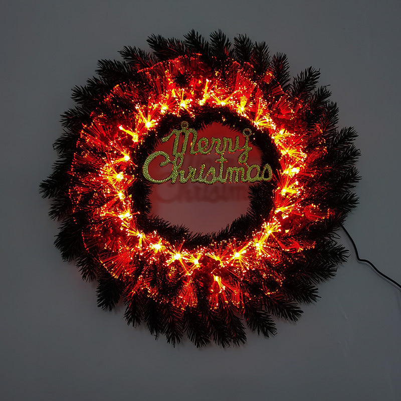 Illuminated Christmas wreath with red lights and green Merry Christmas sign in the center