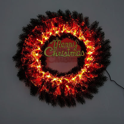 Illuminated Christmas wreath with red lights and green Merry Christmas sign in the center