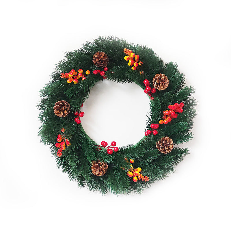Christmas wreath with green pine branches, red and yellow berries, and pine cones on white background