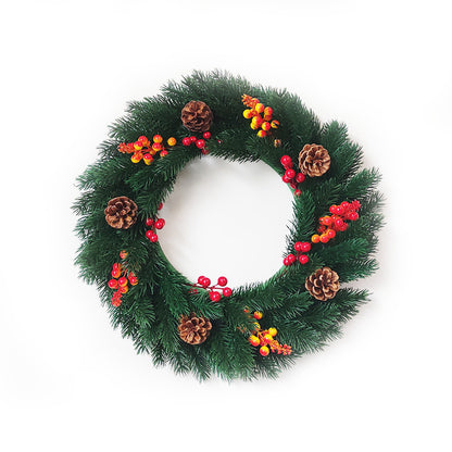 Christmas wreath with green pine branches, red and yellow berries, and pine cones on white background