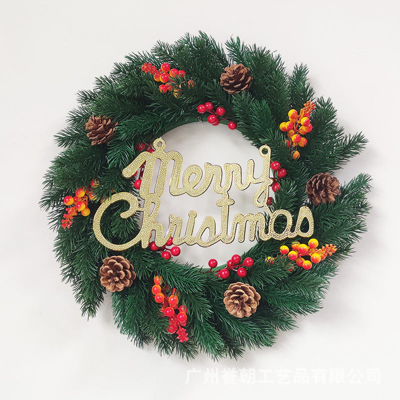 Christmas wreath with green pine branches, red and yellow berries, pinecones, and gold Merry Christmas sign