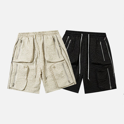 Pair of men's loose workwear shorts in beige and black polyester cotton blend with zippered pockets