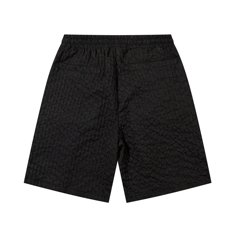 Black men's loose workwear shorts with textured polyester-cotton blend fabric and elastic waistband