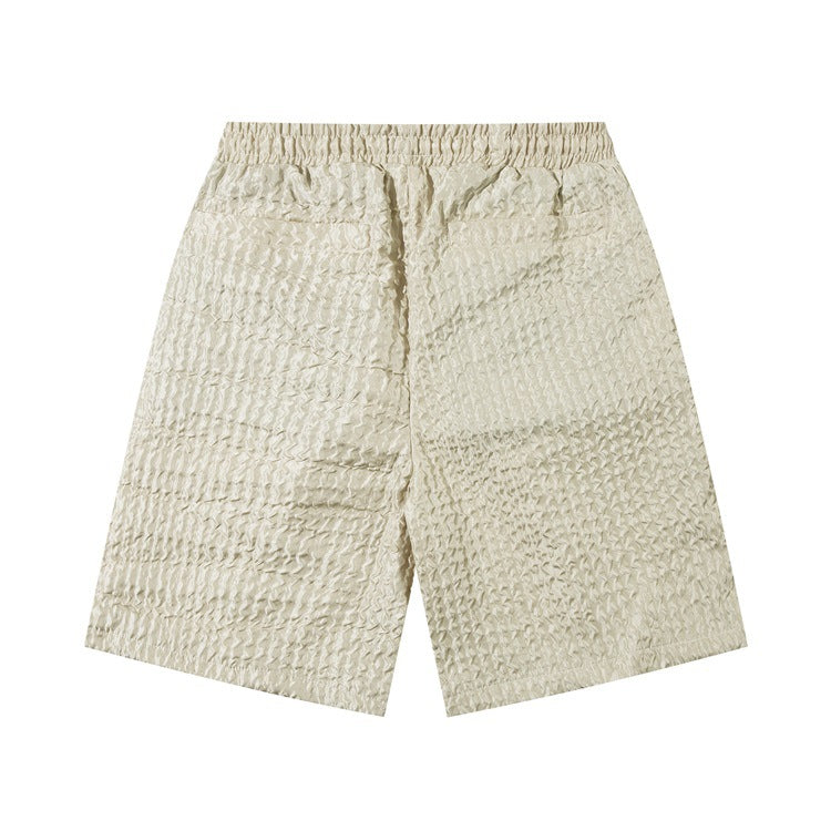 Men's beige textured loose workwear shorts with elastic waistband on white background