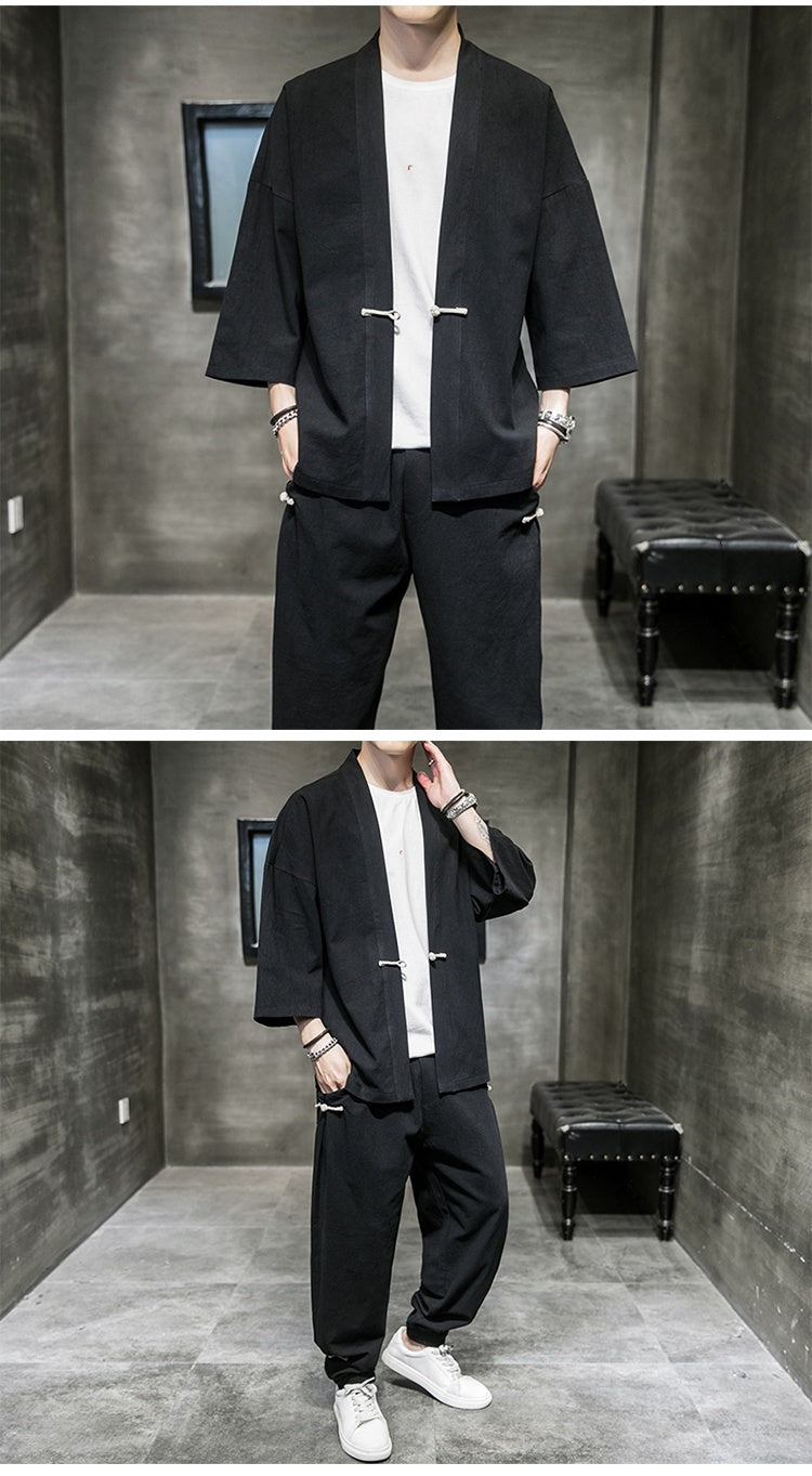Man wearing black loose-fit linen Hanfu suit with white t-shirt and sneakers in modern minimalist room