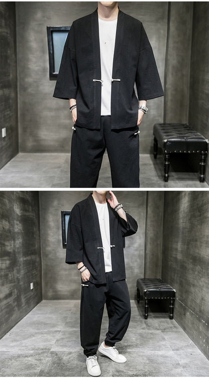 Man wearing black loose-fit linen Hanfu suit with white t-shirt and sneakers in modern minimalist room
