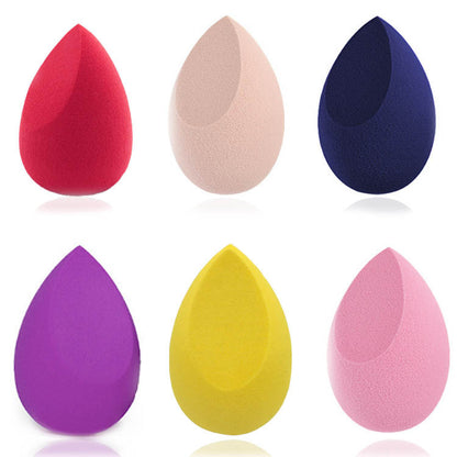 Set of six colorful makeup sponges in red, beige, navy, purple, yellow, and pink on white background
