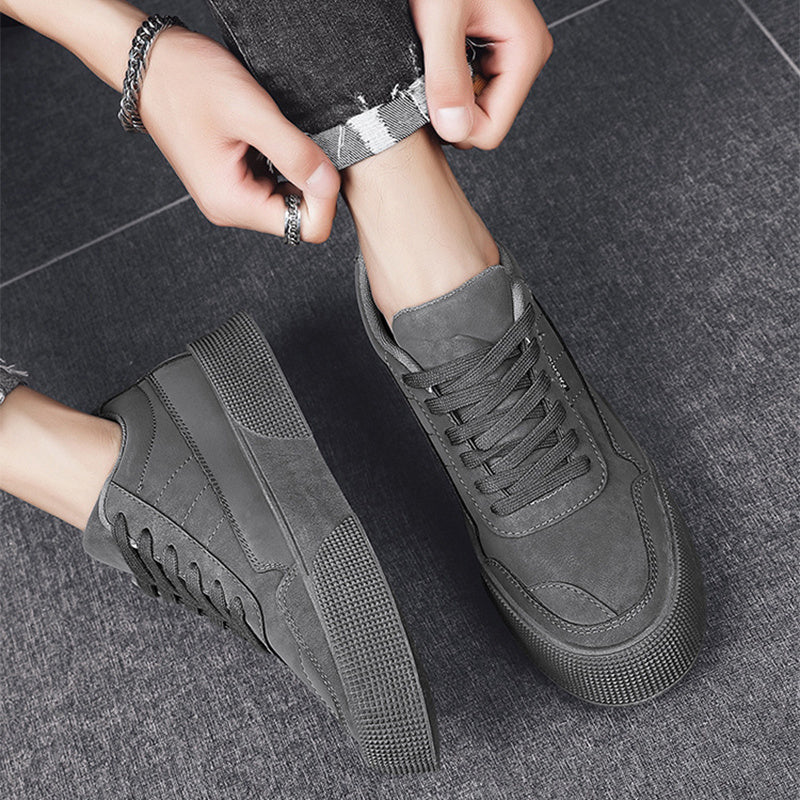 men's gray casual lace-up sneakers with textured sole on gray floor, paired with rolled-up dark jeans