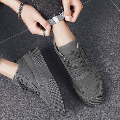 men's gray casual lace-up sneakers with textured sole on gray floor, paired with rolled-up dark jeans