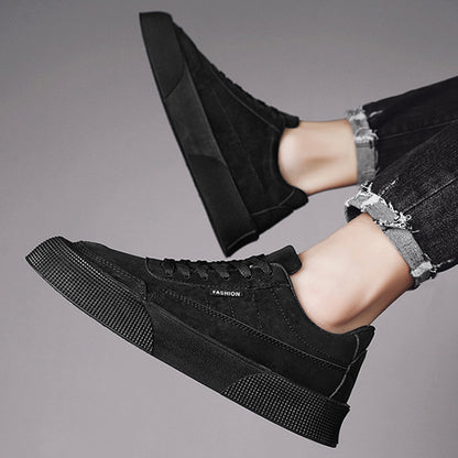 Black casual lace-up sneakers with thick textured sole worn with frayed black jeans