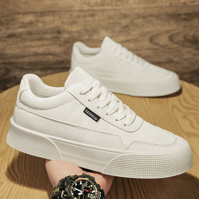 White casual men's sneakers with thick sole, lace-up design, and fashion label, on wooden surface