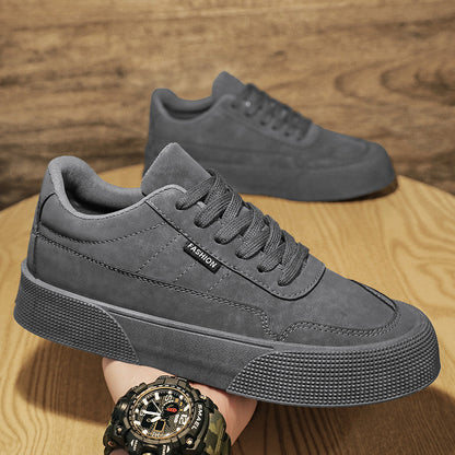 Close-up of grey men's casual sneakers with thick textured sole and lace-up design on wooden surface
