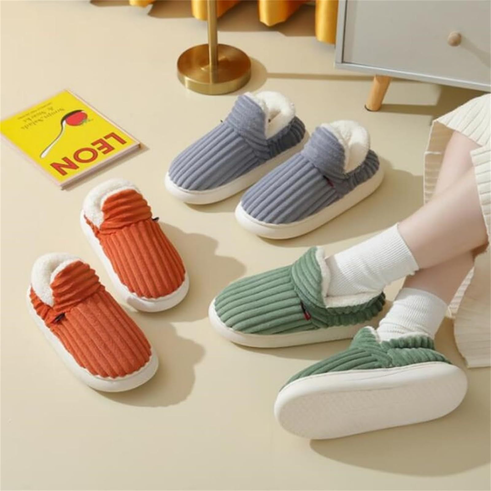 Cozy plush indoor slippers for women and men in green, blue, and orange on beige floor