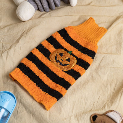 Cozy orange and black striped Halloween dog sweater with glittery jack-o'-lantern design on beige surface
