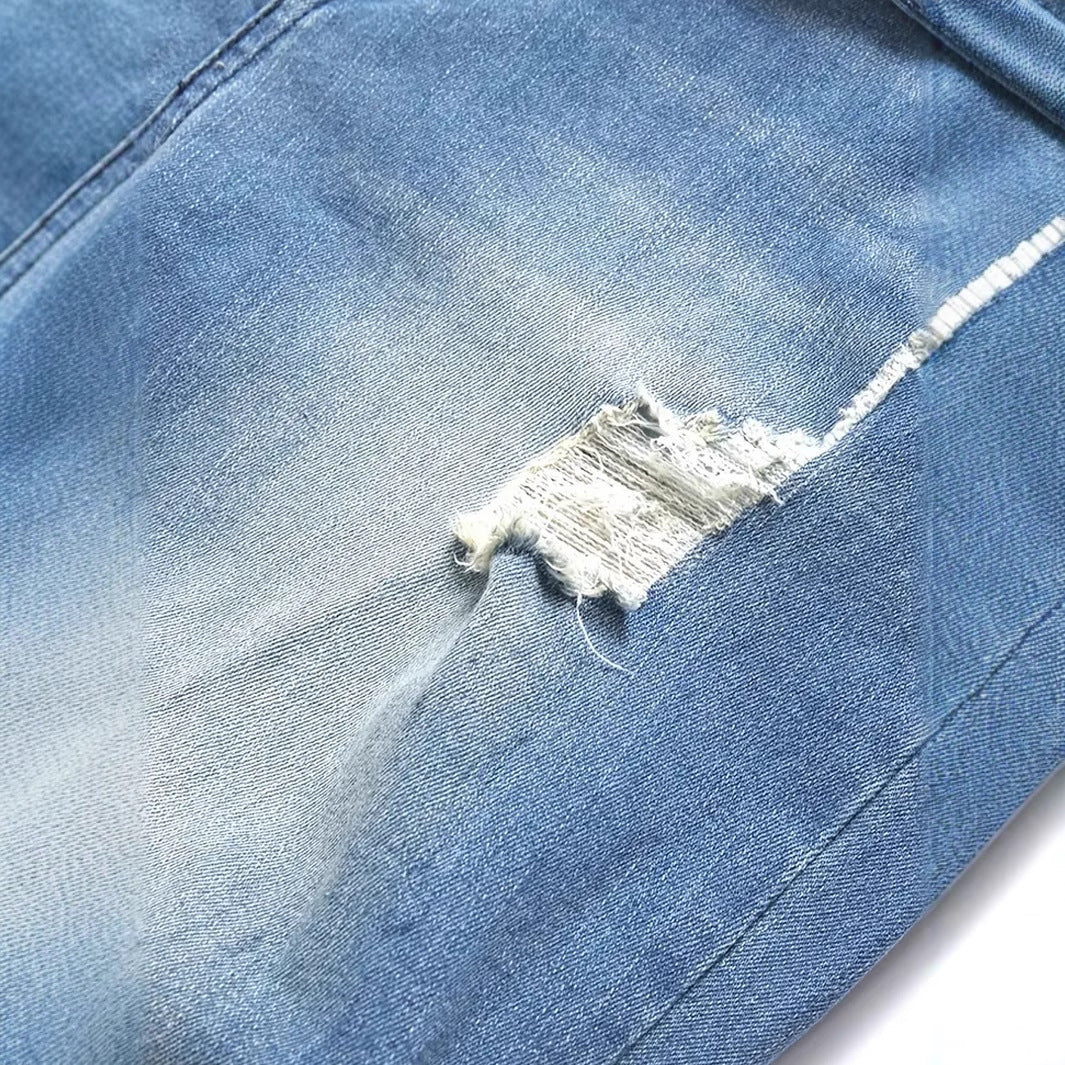 Close-up of peacock blue men's ripped denim jeans with distressed detailing and straight leg fit
