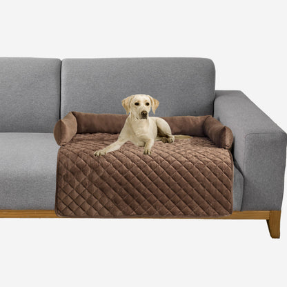 Labrador dog lying on a brown quilted pet sofa bed with bolsters on a gray couch