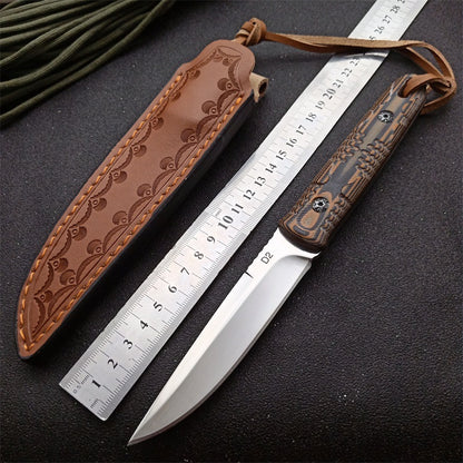 D2 steel folding survival knife with patterned G10 handle and brown leather sheath next to a ruler