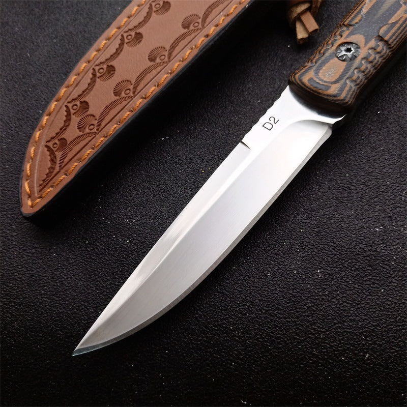 Close-up of D2 steel folding survival knife with wooden G10 handle and decorative brown leather sheath