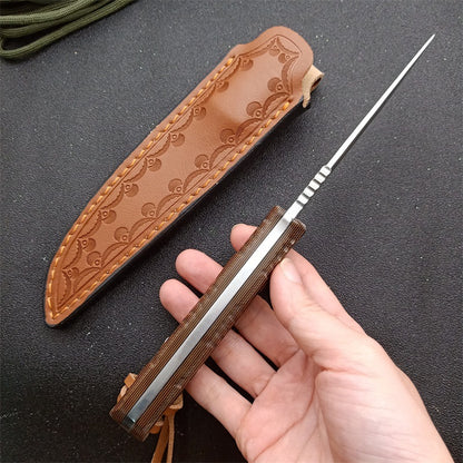 Hand holding a fixed blade knife with wooden handle and a leather sheath on black surface