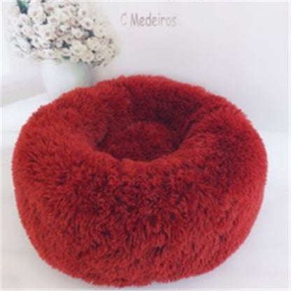 Red plush round pet bed with soft cozy cushion for cats and dogs on white surface
