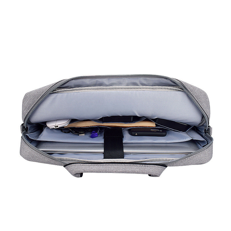 gray laptop shoulder bag open showing organized compartments with laptop, charger, and accessories