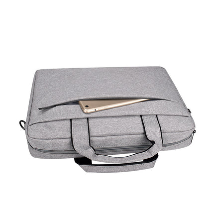 Gray fabric laptop bag with handles and front zipper pocket holding a gold tablet