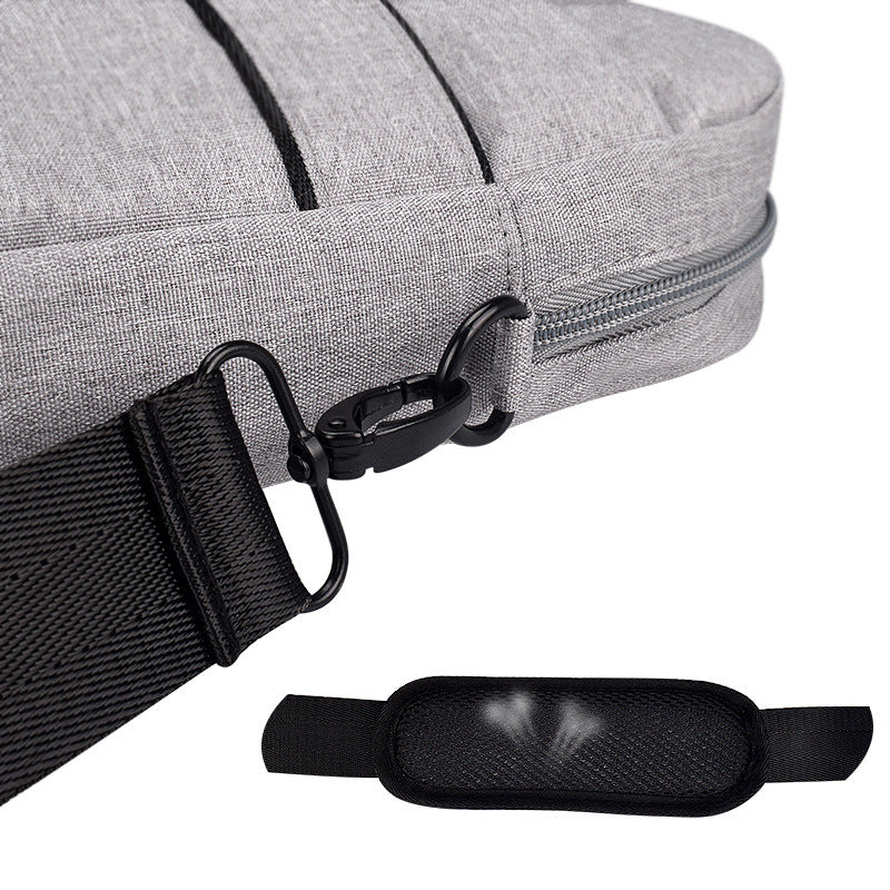 Close-up of gray fabric laptop shoulder bag with black detachable strap and metal clasp