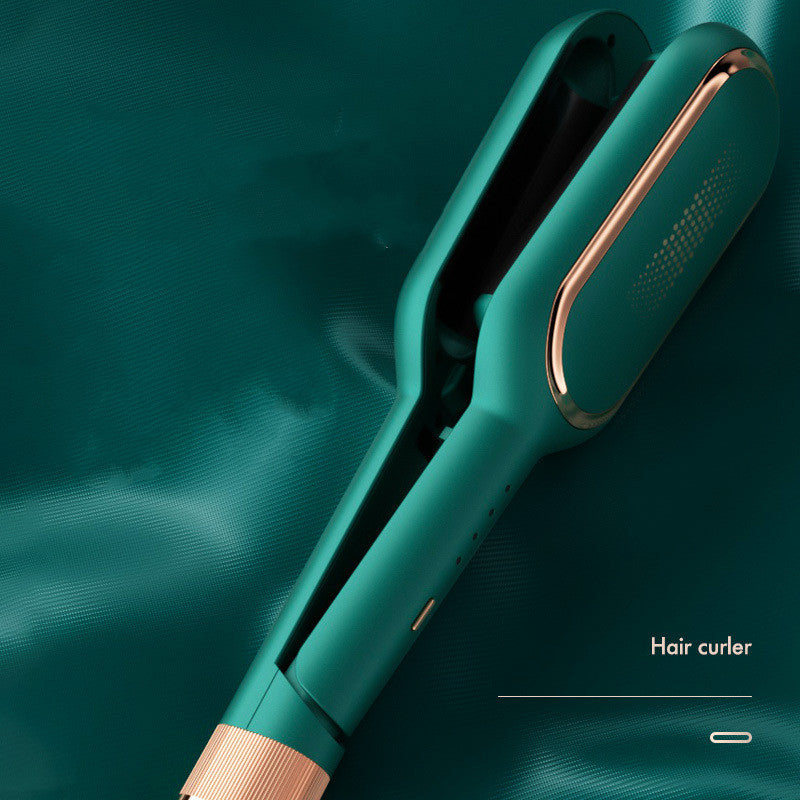 Teal electric hair curler with rose gold accents on matching teal fabric background