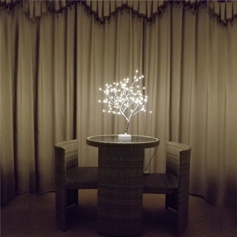 LED bonsai tree night light with glowing pearl star lights on wicker table between two chairs