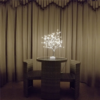 LED bonsai tree night light with glowing pearl star lights on wicker table between two chairs