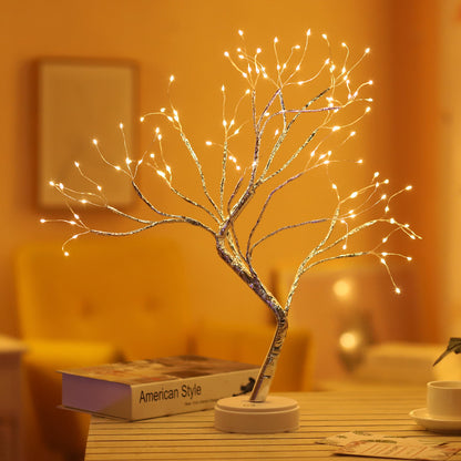 LED bonsai tree night light with warm white fairy lights on wooden table with book and cup