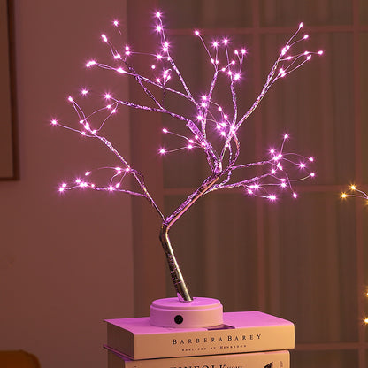 Pink LED bonsai tree light with pearl star night light effect on books in dim room