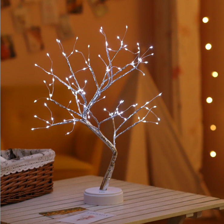 LED bonsai tree night light with white fairy lights on wooden table in cozy room