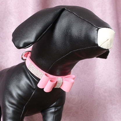 Black leather dog model wearing a pink rhinestone suede collar with a decorative bow