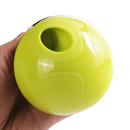 Hand holding a lime green slow feeder pet toy ball with textured grip and treat opening