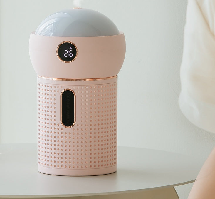 Pink USB humidifier with star projector and digital display on white table in minimal room