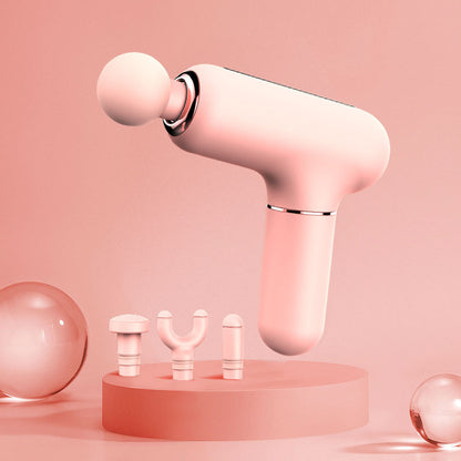 Pink mini massage gun with three interchangeable heads on a round platform with pink background