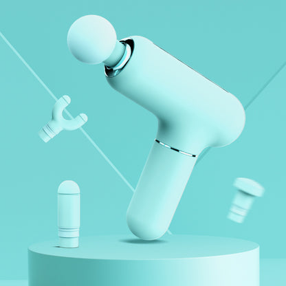 Mint green mini massage gun with round head and three interchangeable attachments on matching pedestal