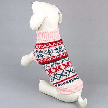 White dog mannequin wearing pink, red, and green patterned cozy autumn dog sweater