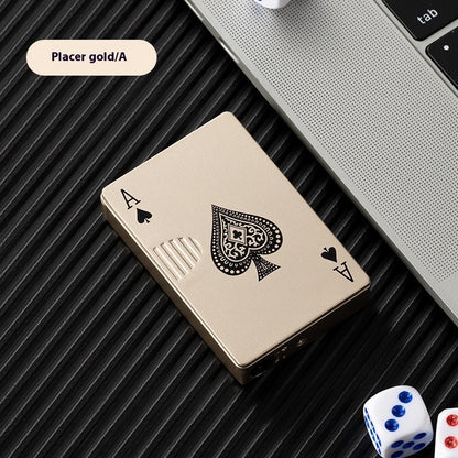 Placer gold zinc alloy poker card lighter with ace of spades design on black textured surface next to laptop and dice